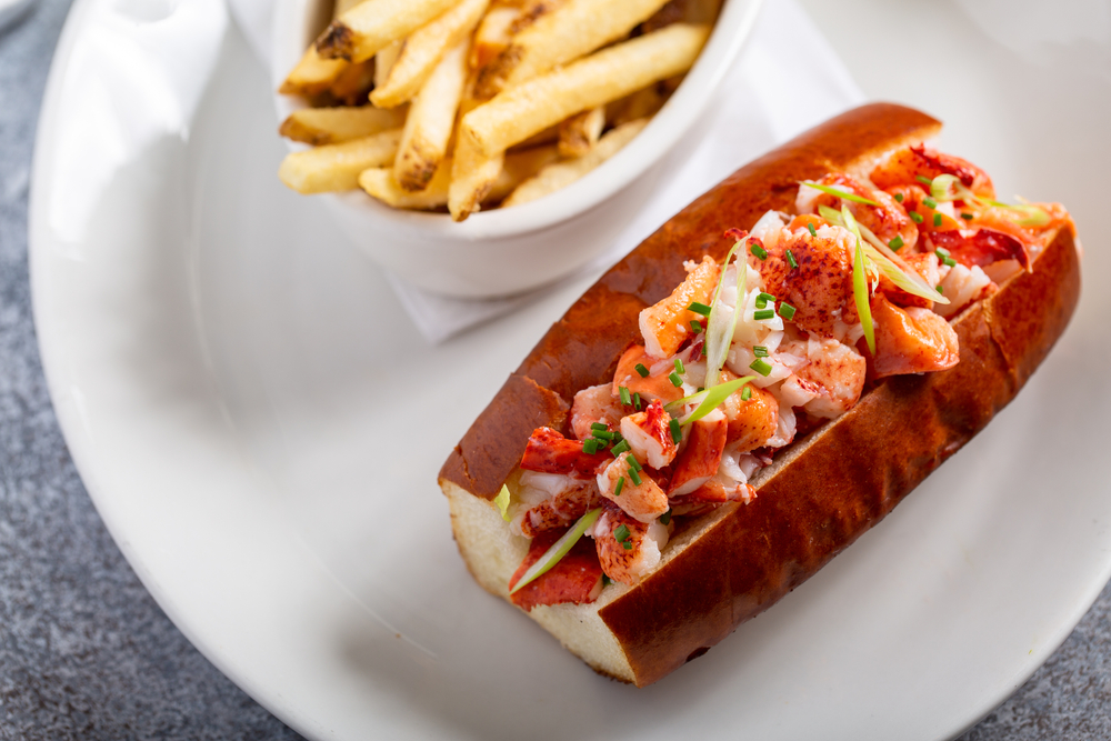 Lobster roll served with fries and white wine for lunch or dinner