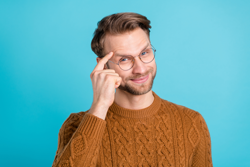 Photo of smart happy cool charming man hold finger temple idea genius isolated on blue color background