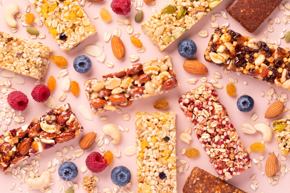 Granola bars. Different tastes. Healthy energy bars made of cereals, berries, nuts and fruits on a light pink background. Space for the text. Top view. Muesli.