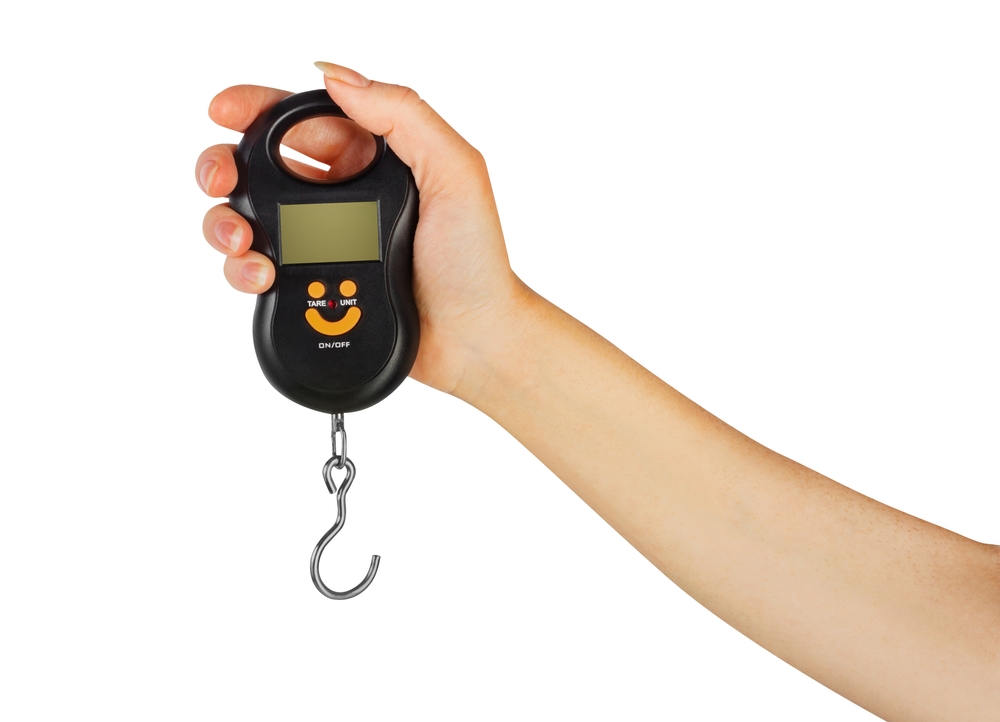 Isolated photo of female woman hand holding counter scales tool with digital screen on white background.