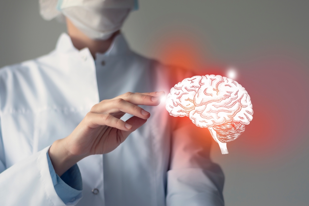 Female doctor touches virtual red Brain in hand. Blurred photo, handrawn human organ, highlighted red as symbol of disease. Healthcare hospital service concept stock photo