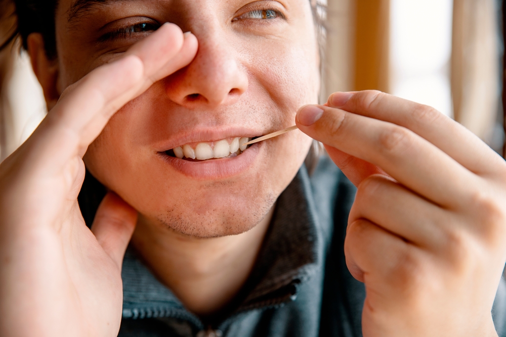 Man Cleaning teeth with a toothpick hiding mouth with hand. Male using Disposable Double-end Teeth Stick Floss Pick to clean teeth. Toothpick Dental Brush Oral Care concept
Man Cleaning teeth with a toothpick hiding mouth with hand. Male using Disposable Double-end Teeth Stick Floss Pick to clean teeth. Toothpick Dental Brush Oral Care concept