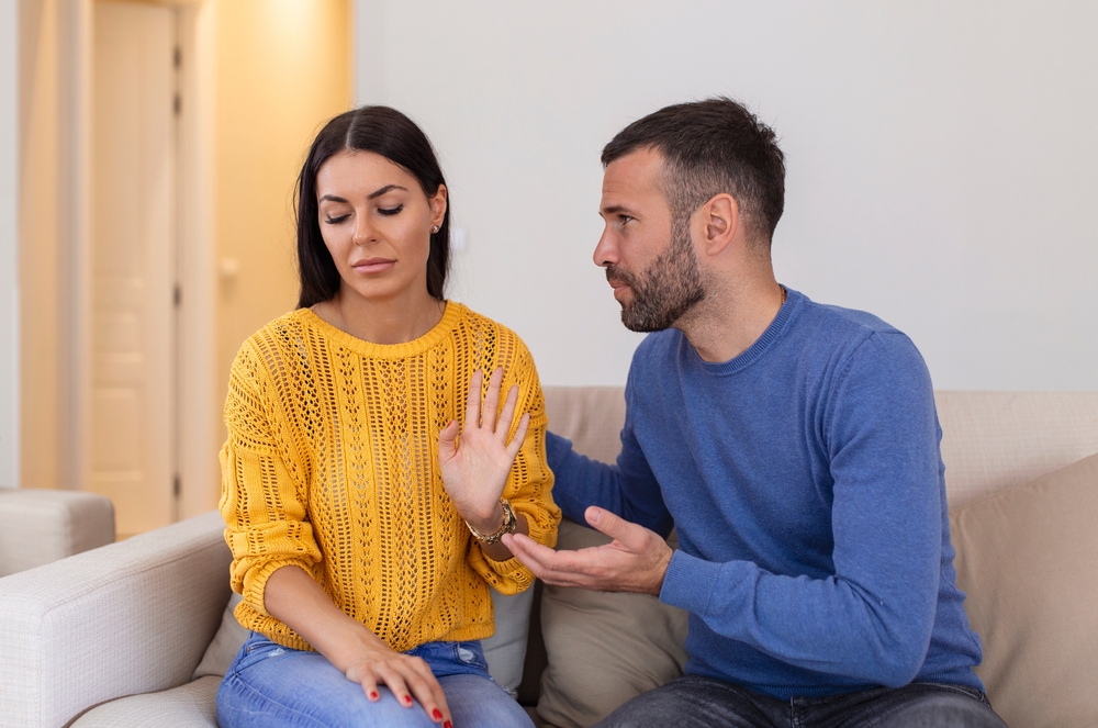 Stressed young man saying sorry after quarrel to frustrated wife. Depressed offended woman ignoring apologizing husband . Family relations problems, divorce, break up concept.