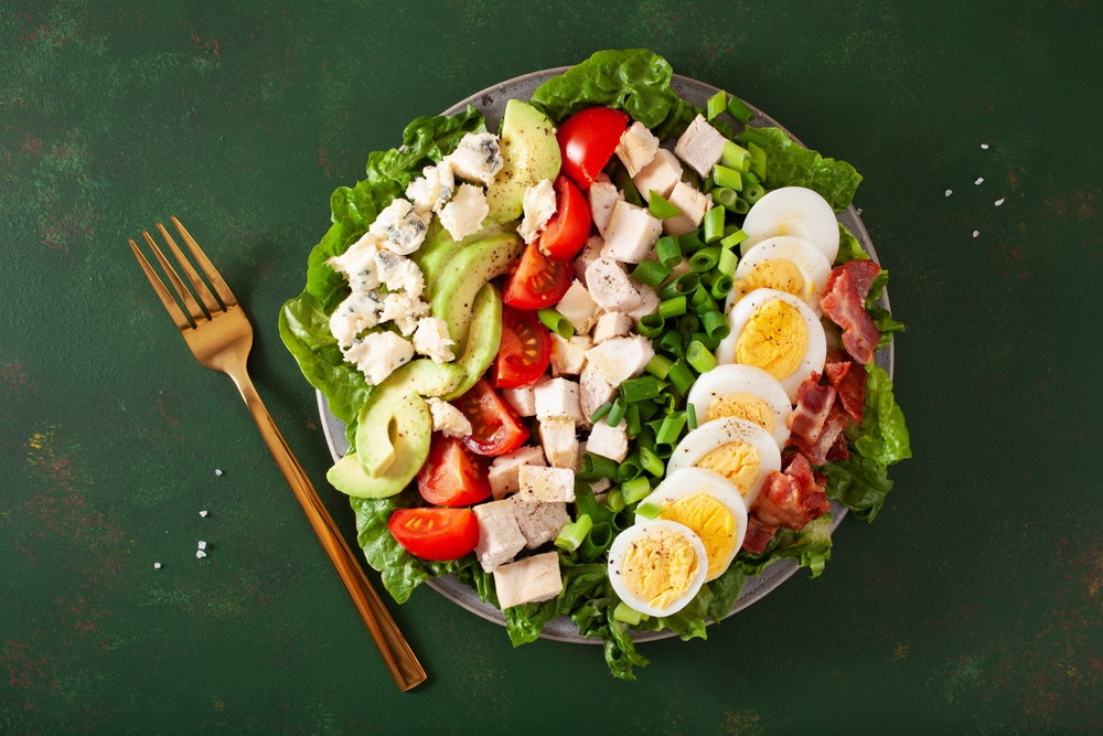 healthy American Cobb salad with egg bacon avocado chicken tomato. hearty keto low carb diet