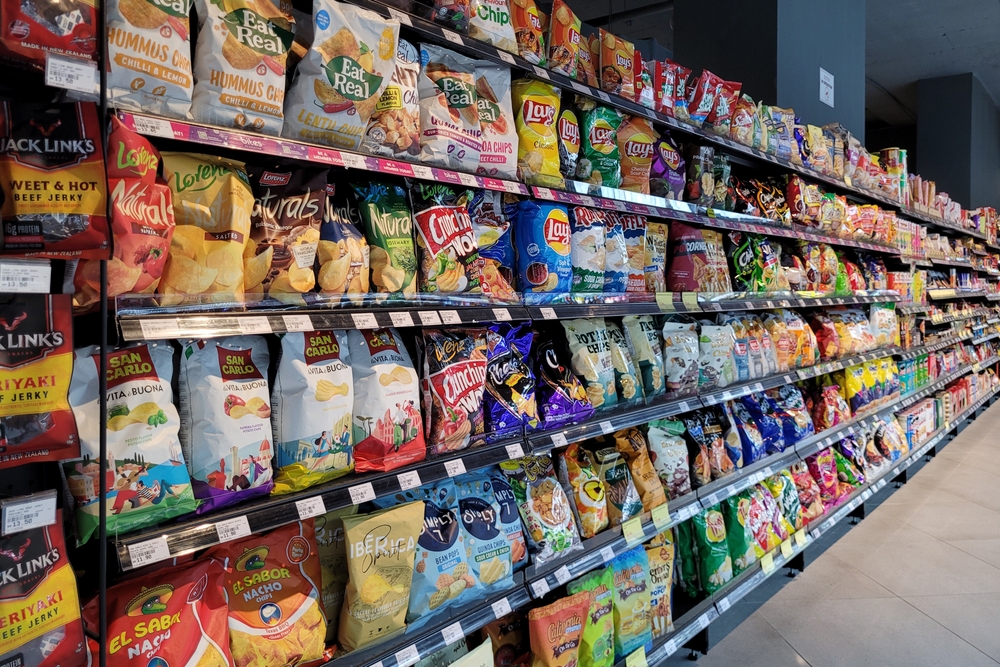 PENANG, MALAYSIA - 2 APR 2023: Various brands of flavoured chips and snacks on store shelf in Village Grocer store. Village Grocer is the coolest fresh premium supermarket in Malaysia.