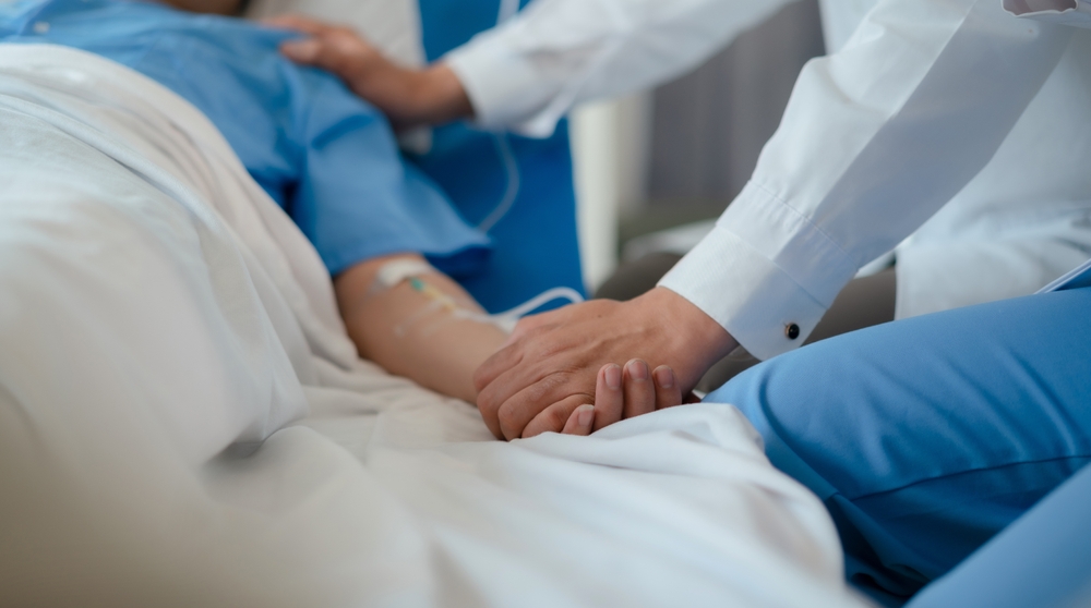 doctor check up after surgery. doctor touching patient hand and consoling.
