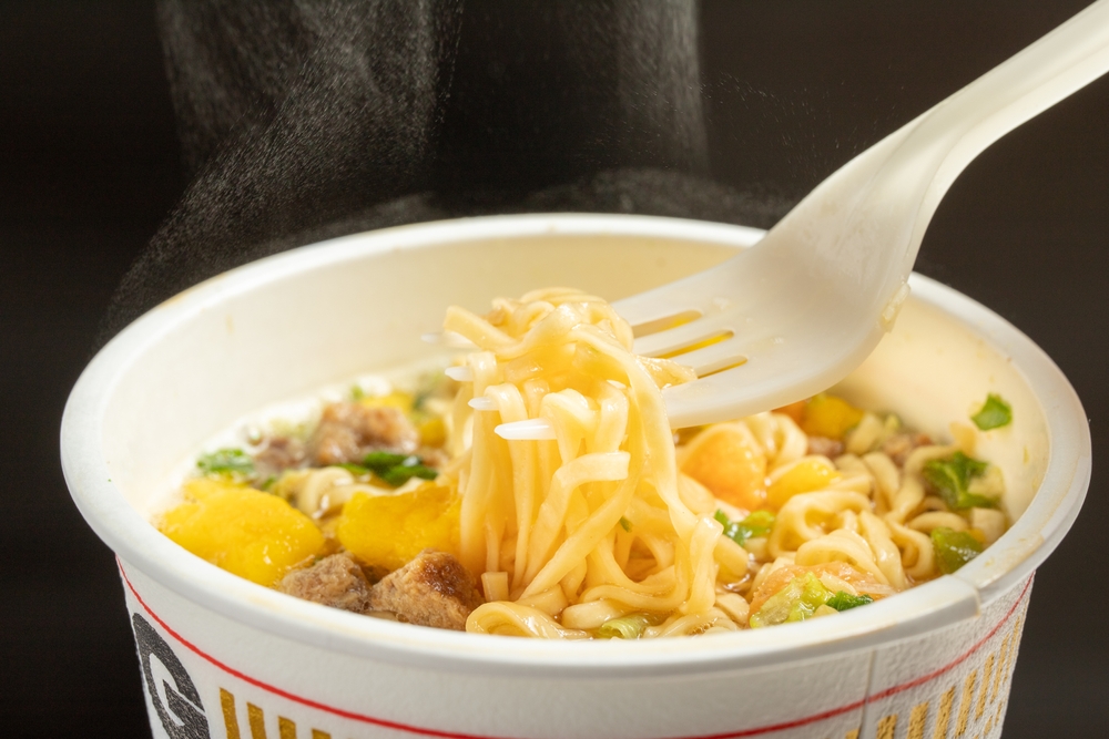Eating hot cup noodles with a fork
