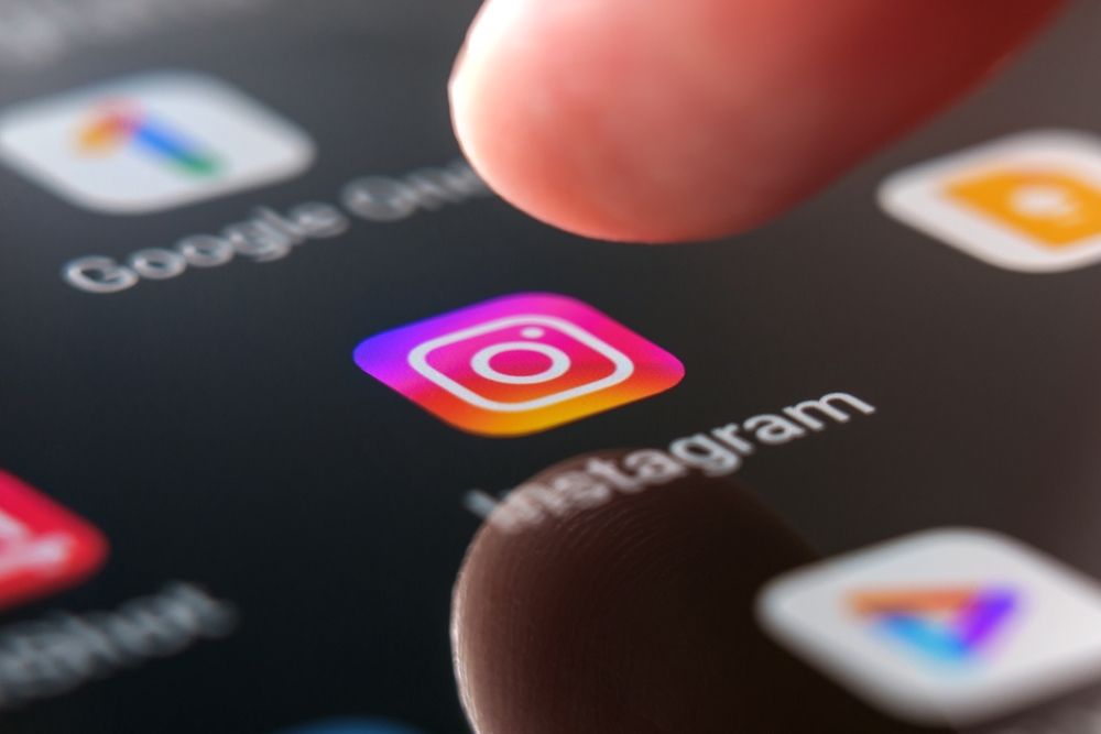 Oviedo, Spain - July, 04, 2023: Instagram app logo on smartphone screen with pressing finger. Global social network