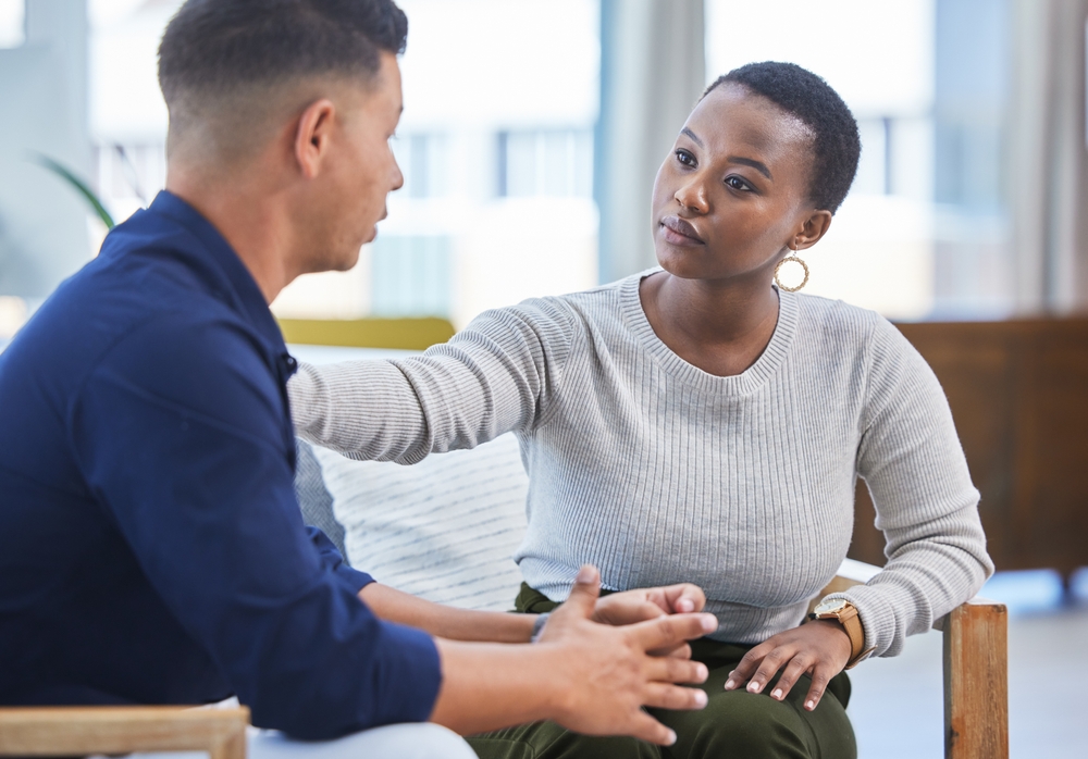 Black woman, office and console man in stress, panic or talking with mental health support in workplace. Professional, businesswoman and care for employee, coworker or management of work pressure
