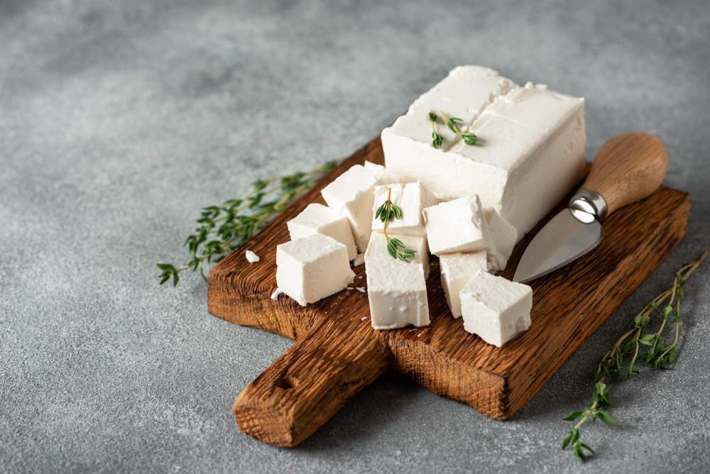 Festa cheese cubes, gray concrete background. Side view, selective focus.