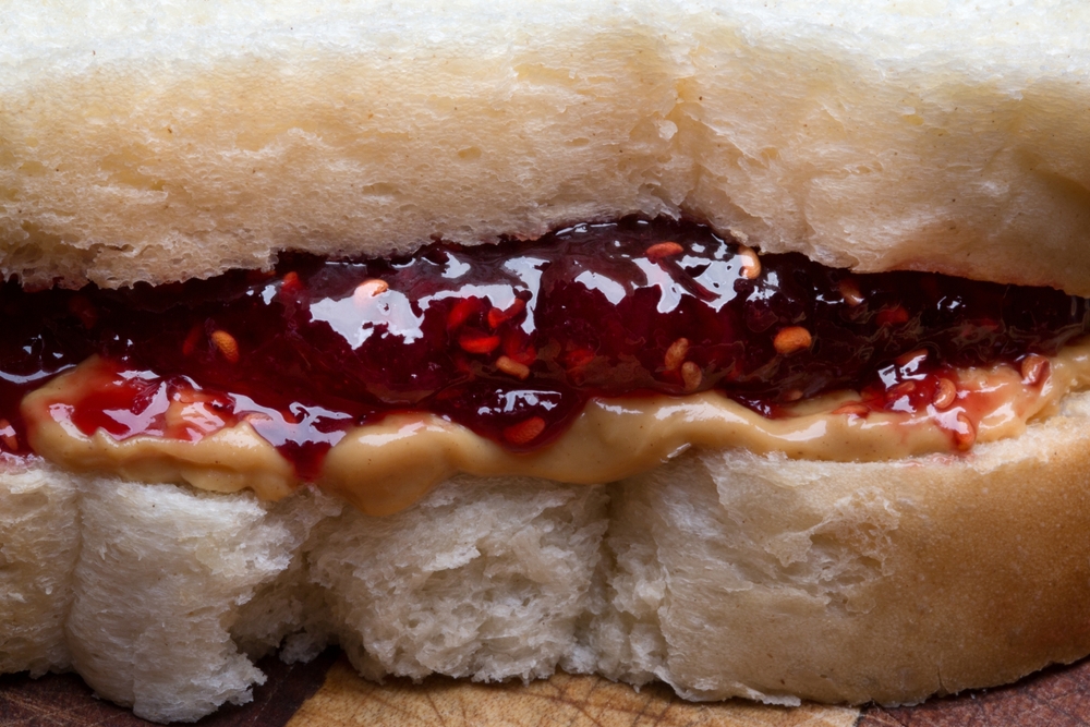 4K Image of Classic Peanut Butter and Jelly Sandwich Macro Shot on Rustic Cutting Board