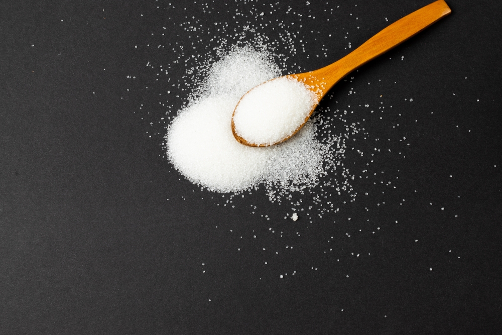 White sugar and wooden spoon