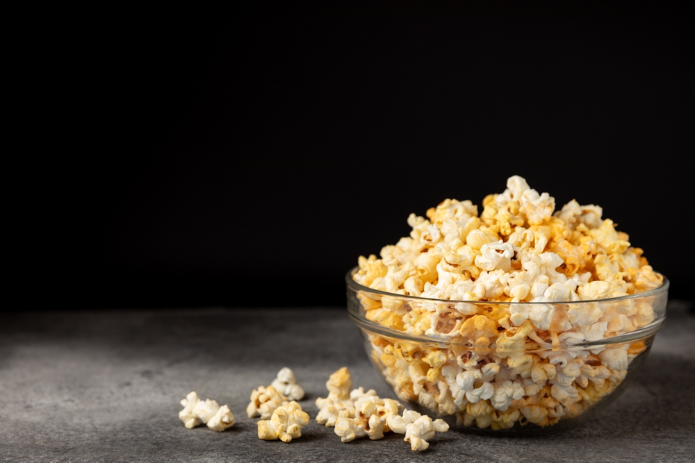 Tasty popcorn on wooden background. Cinema and entertainment concept. Movie night with popcorn.Cheese and caramel popcorn. Delicious appetizer, snack. Place for text. Copy space.Banner