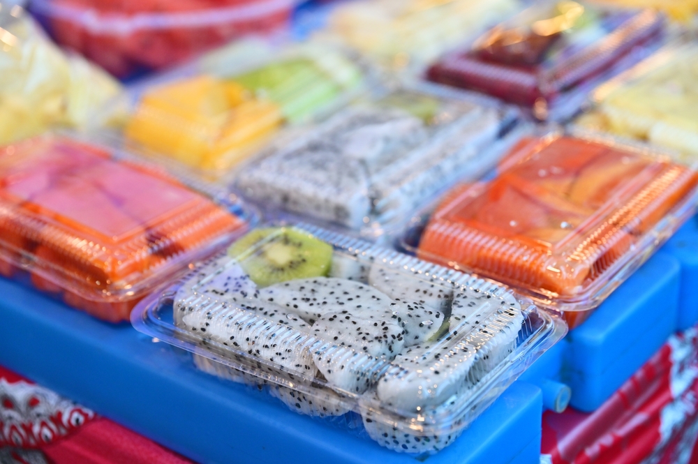 Photograph of pre-cut fruits neatly arranged in transparent boxes at a market or supermarket stall, enhancing convenience for shoppers.
