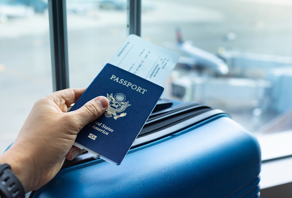 Passport in travelers hand at the airport.