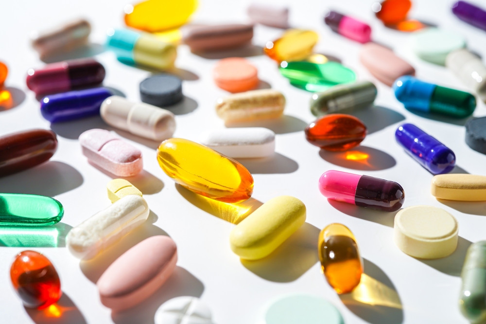 A lot of colorful medication pills capsules tablets softgel supplements, fish oil, vitamin, omega 3