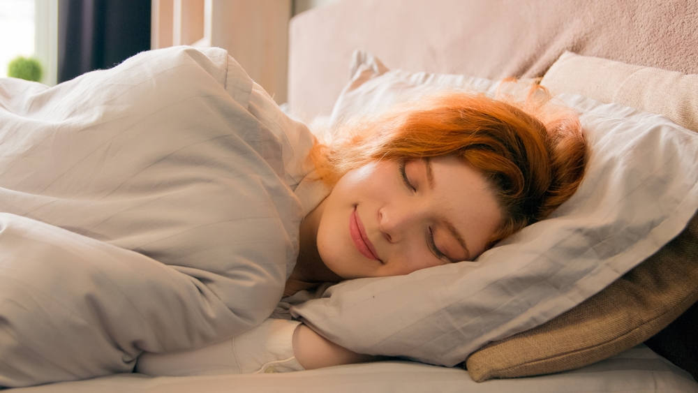 Caucasian happy woman sleeping in comfortable cozy bed at home girl lady asleep lying on soft pillow white linen orthopedic mattress resting relaxing napping healthy sleep nap in morning stress relief