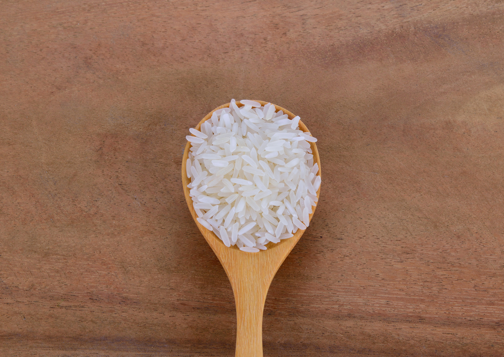milled rice on wood spoon and Wooden Floor