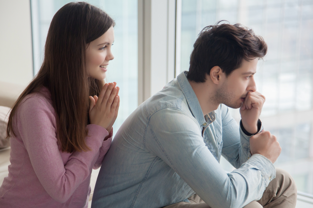 Young woman apologizing upset frustrated man at home. Girlfriend asking boyfriend for forgiveness. Girl trying to convince guy to forgive her telling she regrets. Excuses, saying Iâ??m sorry, please