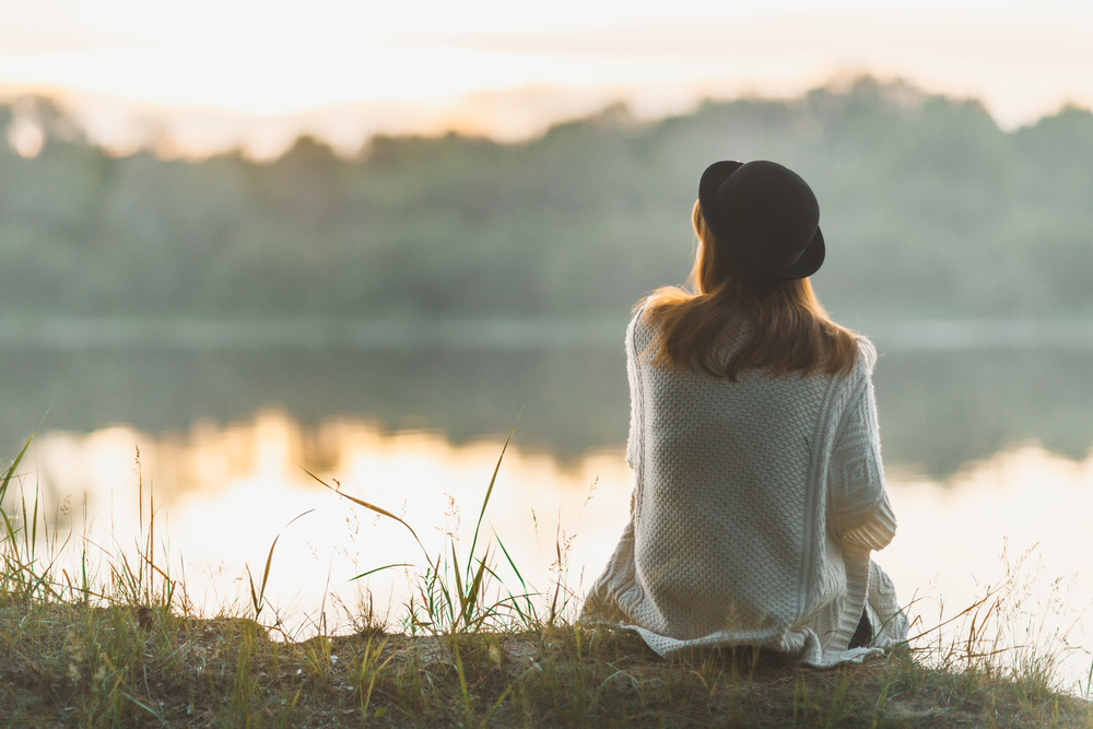 woman sitting near waterf