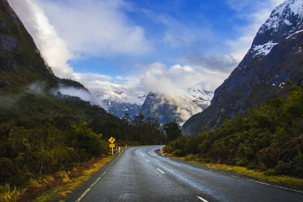 perspective photography of road to milford sound national park most popular natural traveling destination in southland new zealand