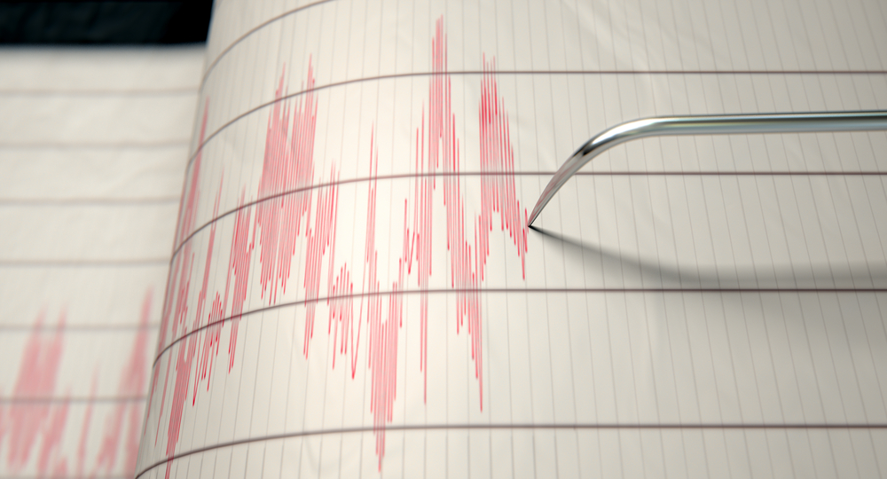 A closeup of a seismograph machine needle drawing a red line on graph paper depicting seismic and earthquake activity - 3D render