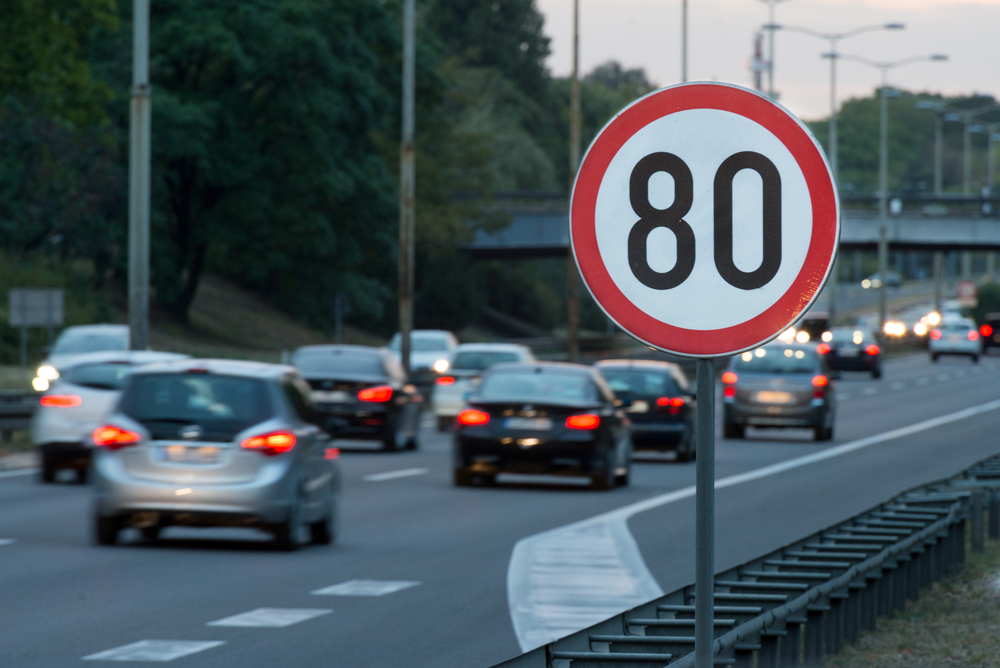 Speed limit sign with a traffic in the background