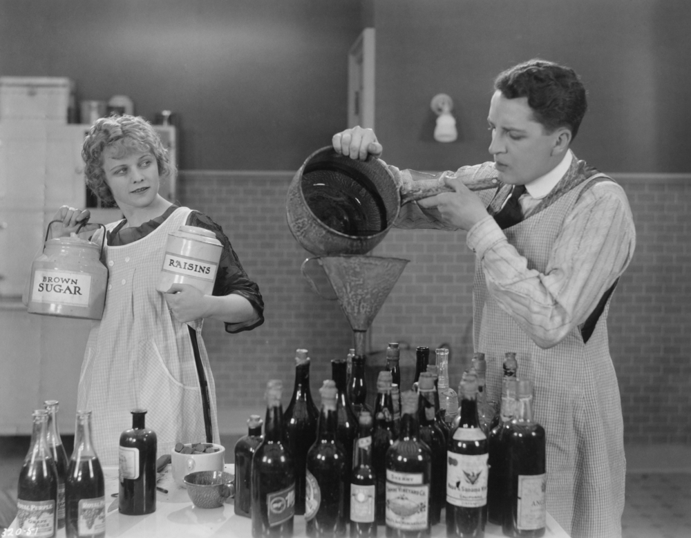 black and white image of people making alcohol