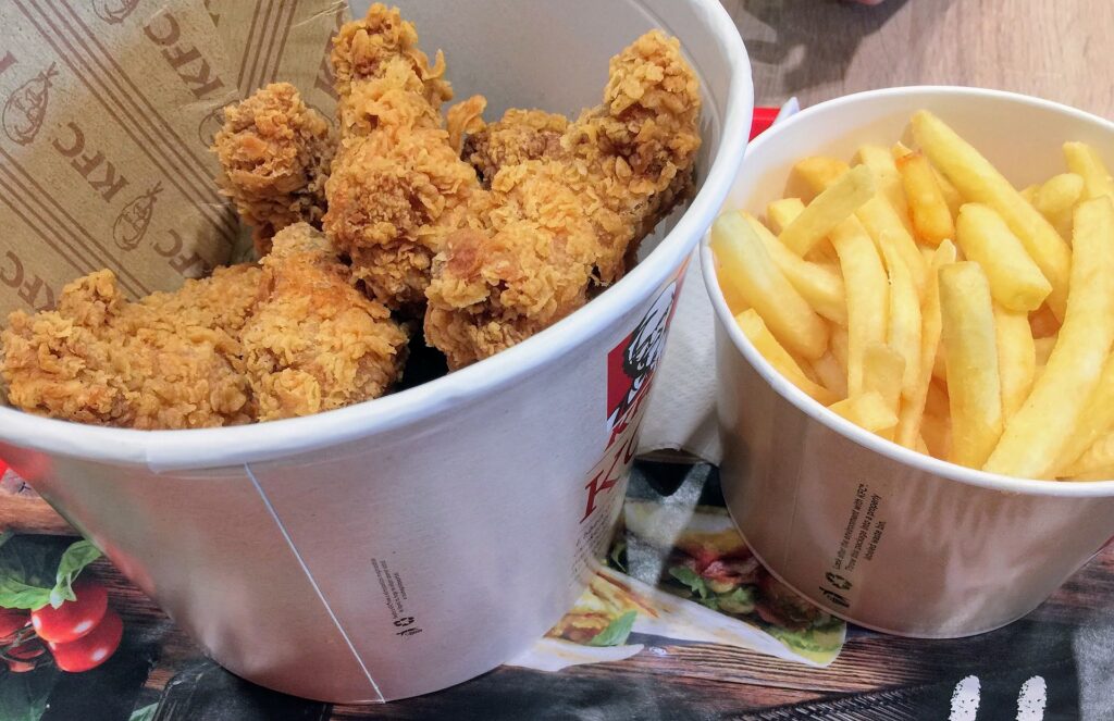 Hot wings and fries served in paper buckets

