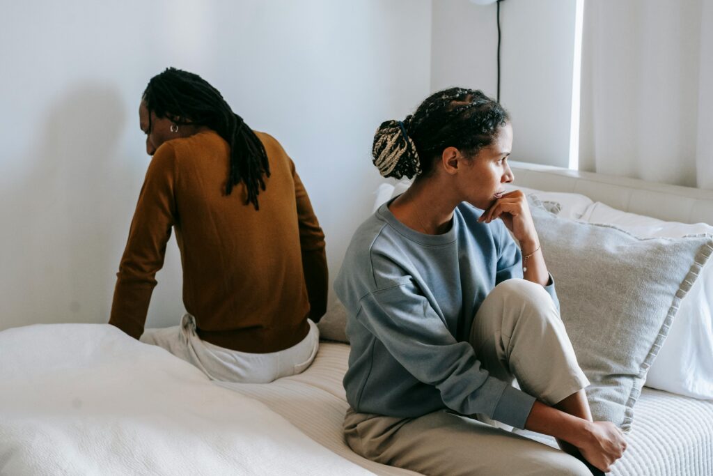 sad couple sitting pn bed