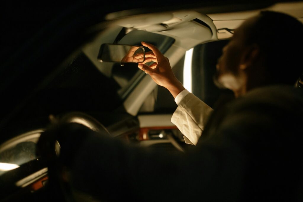 man adjusting his rear mirror