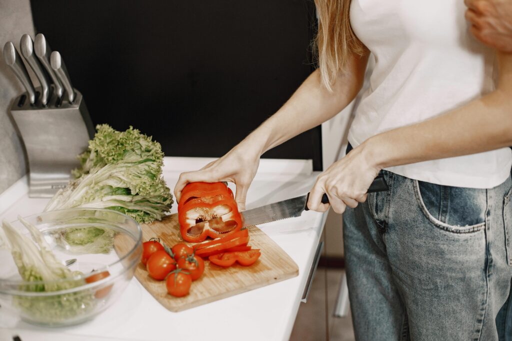 Close-Up Shot of a Person Cutting a Red Bell Pepper