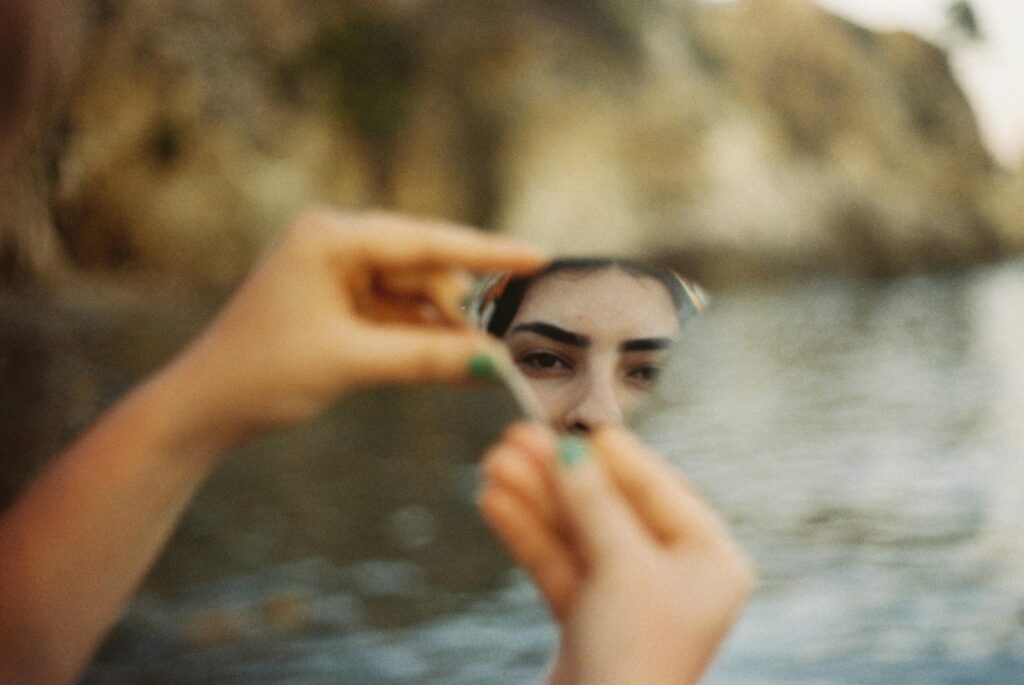 woman looking into mirror