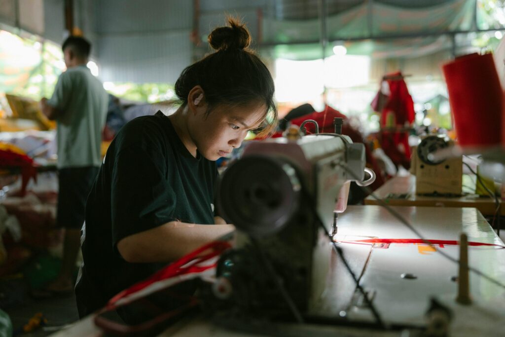 Asian factory worker at sewing machine