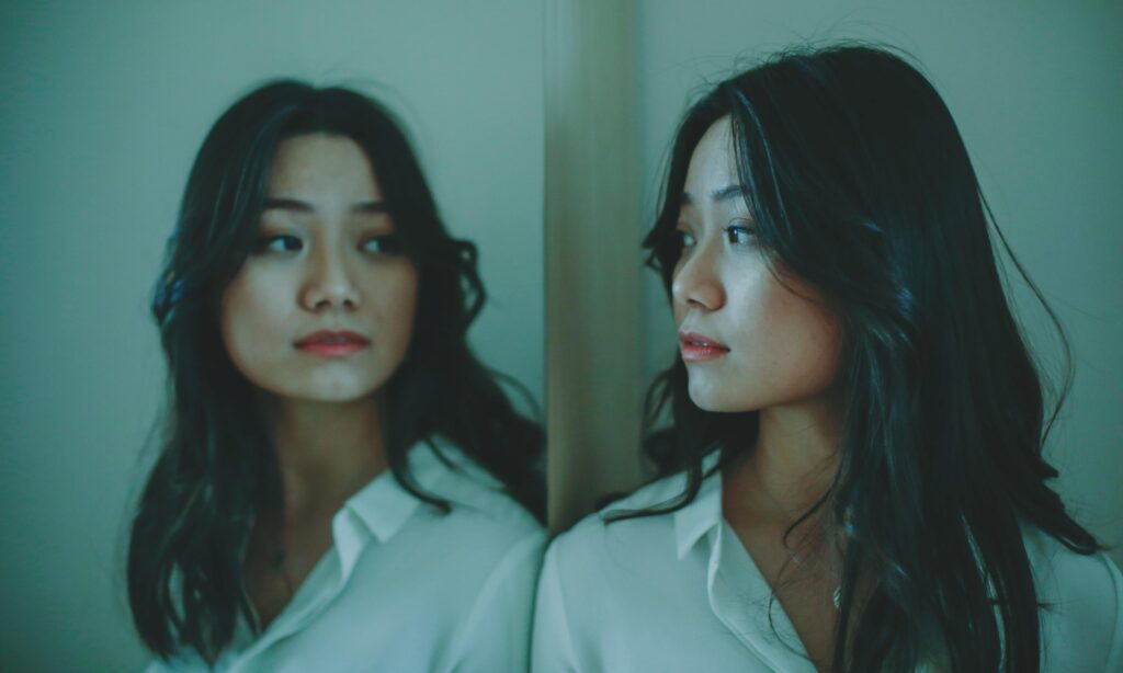 asian woman looking in mirror