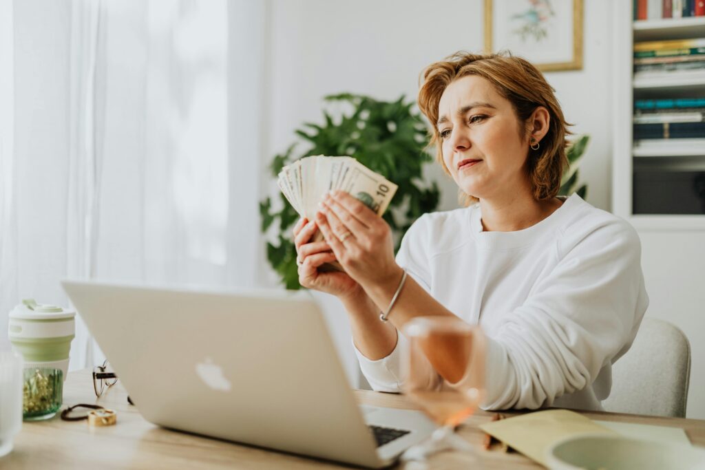 woman sitting at desk, counting money 