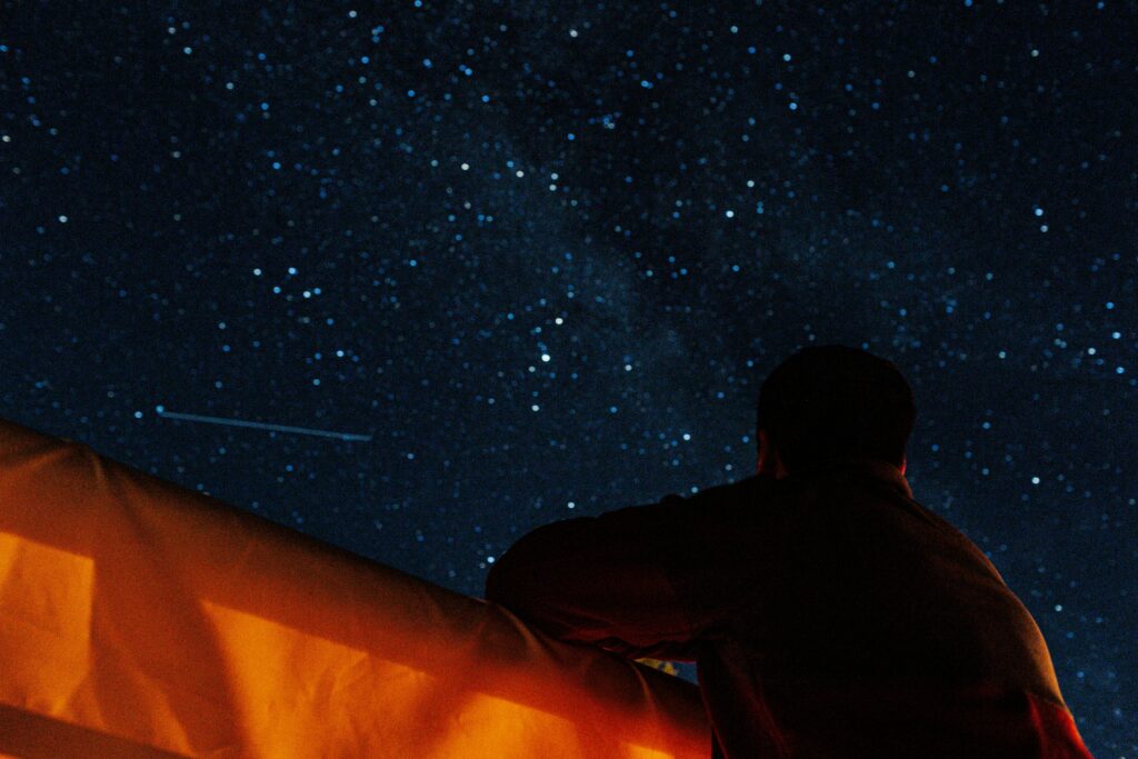 man looking at flash in sky