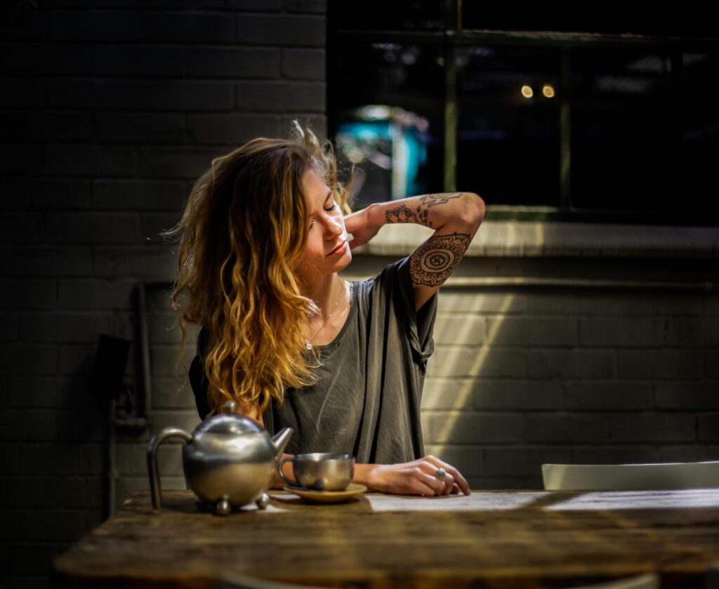 woman at table with tea pot