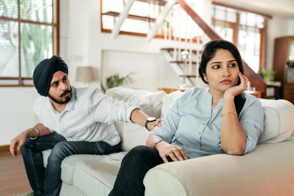 angry indian couple sitting on couch