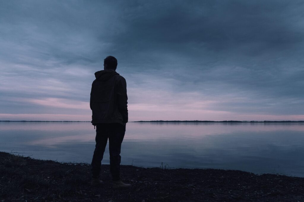 man standing near water