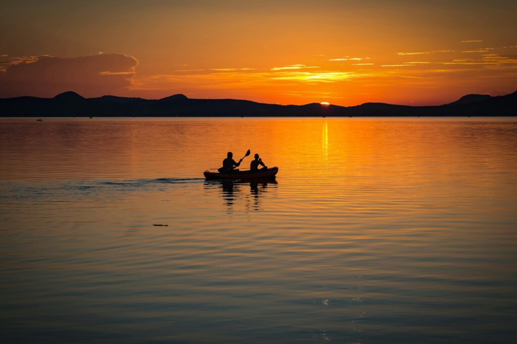 two people on a canoe at sunset