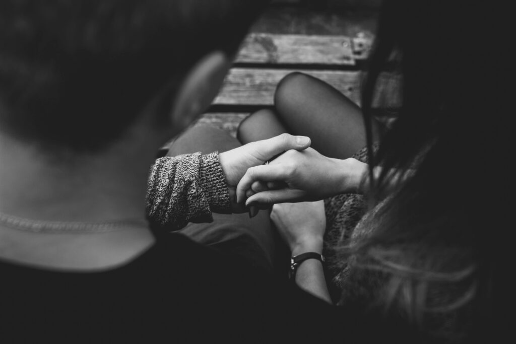 black and white image of man holding womans hand
