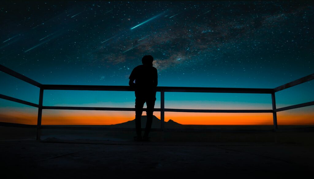 man looking at shooting stars