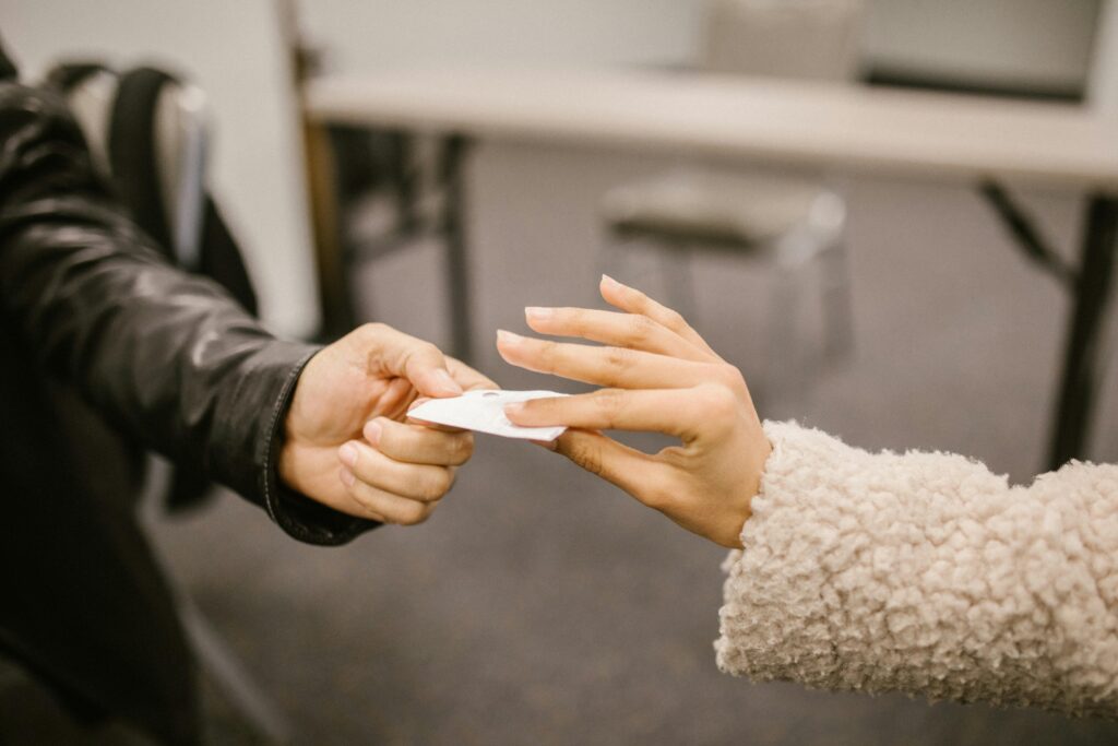 hand passing a note to another hand