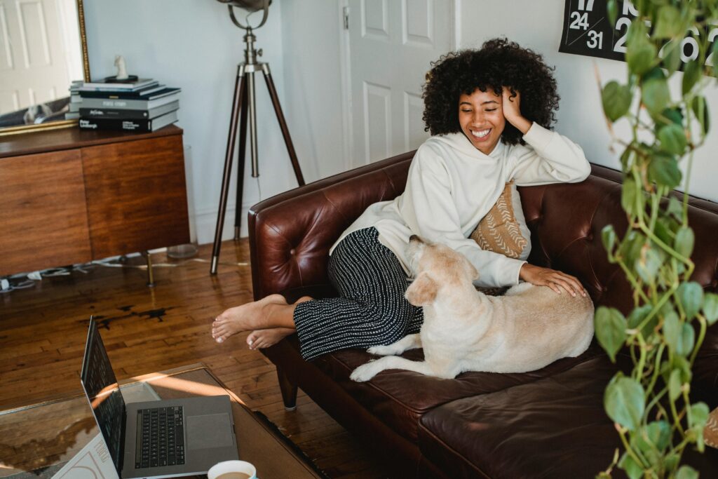 woman sitting on couch with her dog 