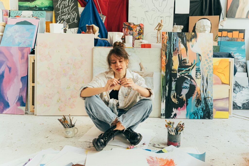Young Artist against Paintings
