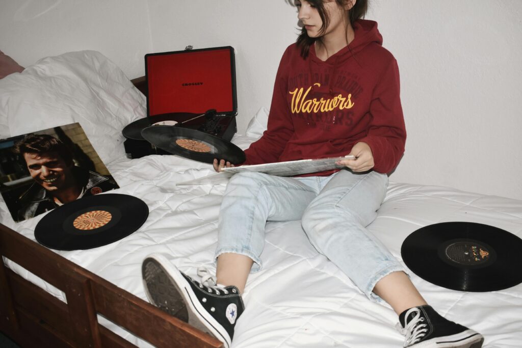 teenage girl on bed with records