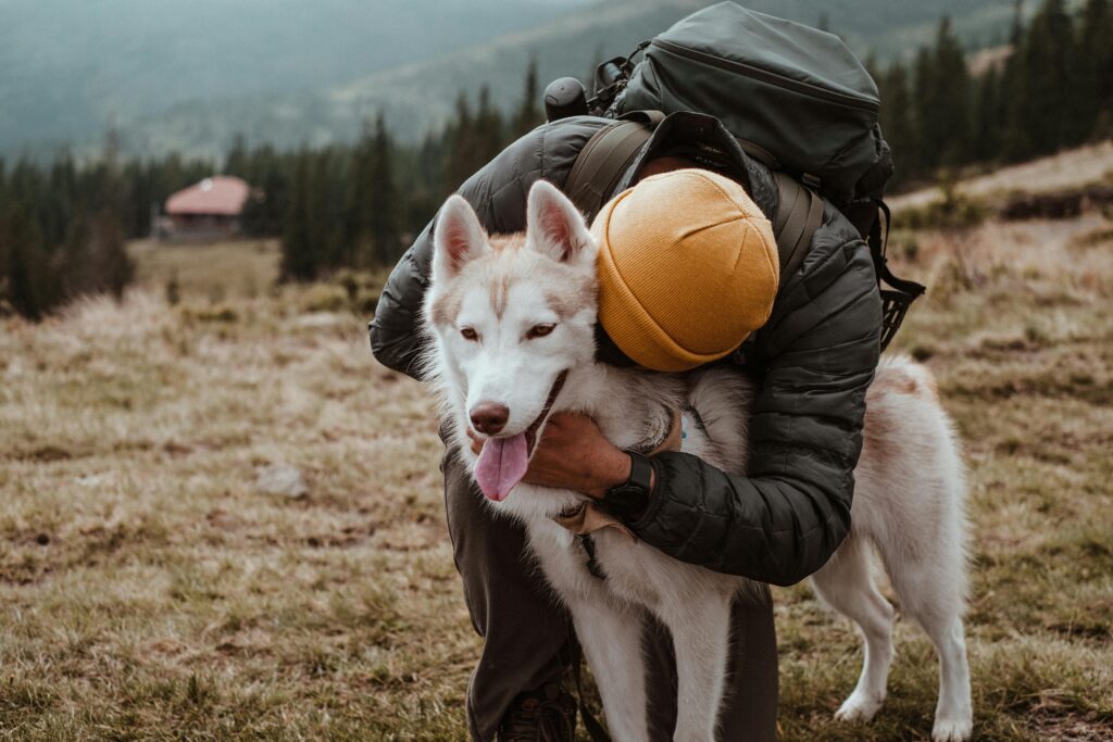 man hugging his husky 
