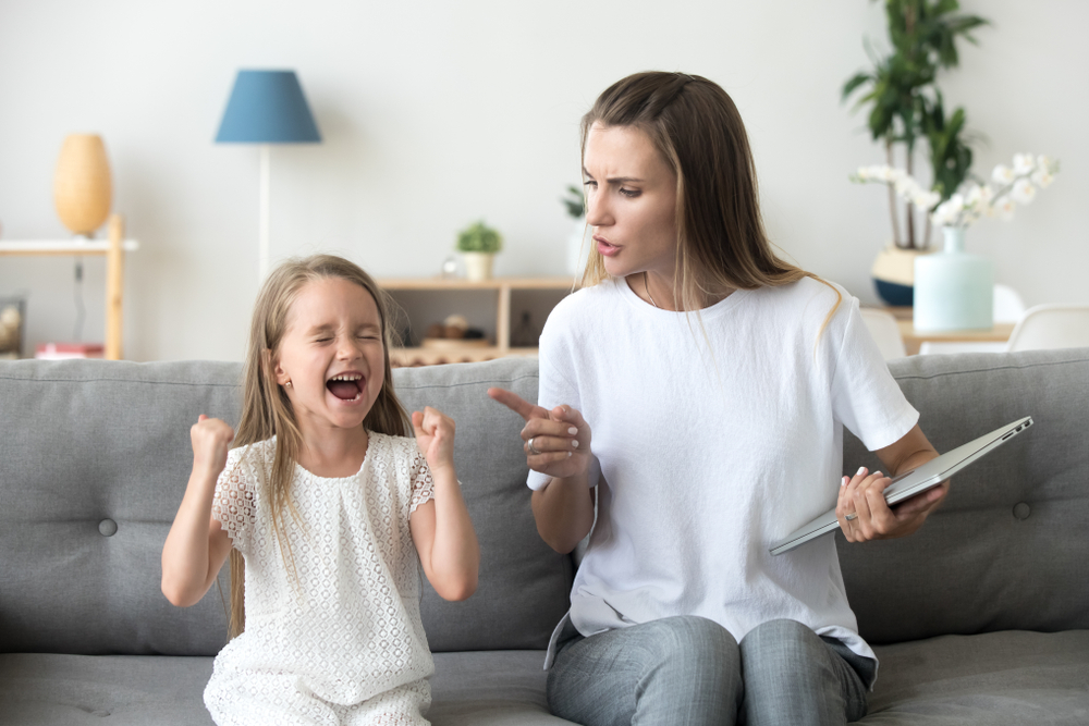 Stubborn little girl scream loud not listening to strict mom, serious young mother scold shouting daughter for bad behavior, working mommy lecture kid yelling asking attention. Family conflict concept