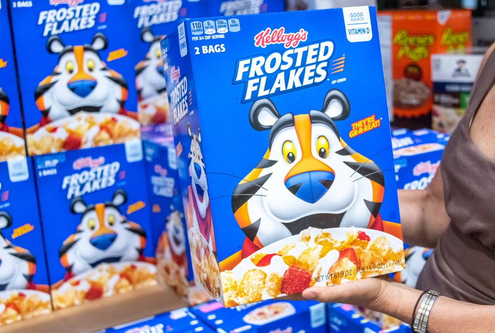 Sacramento, CA/USA 06/06/2019 Shoppers hand holding a family size package of Kellogg's brand frosted flakes cereal in a supermarket aisle
